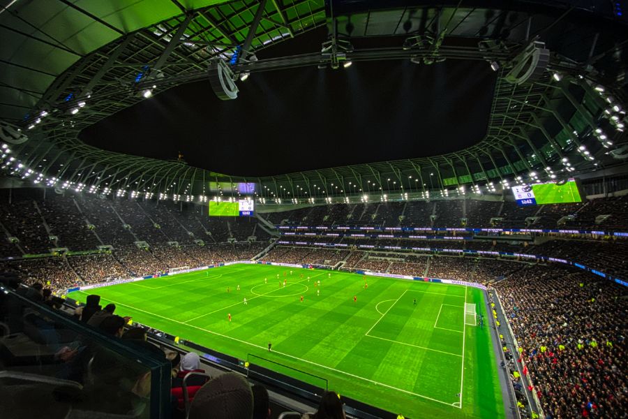 Ein Fußballstadion, während einem Spiel, mit Blick von einer höheren Reihe.